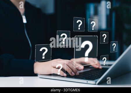 Online Question and Customer Support Inquiry Concept. Woman using laptop with question mark icons, symbolizing online help, customer support, Stock Photo