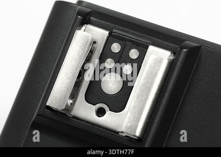A close-up of a DSLR hot shoe mount or flash trigger on a white background. Photography equipment. Stock Photo