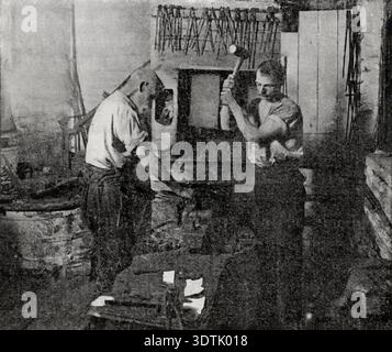 Forging knives in industrial factory - two men with hammers at anvil Stock Photo
