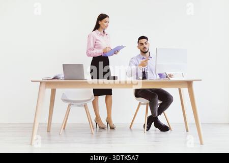 Discussion Between Two Professionals in a Modern Office Setting Stock Photo
