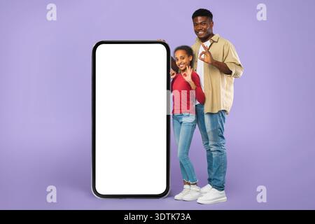 Two People Standing Next to a Large Blank Screen in a Studio Setting at a Fun Event Stock Photo