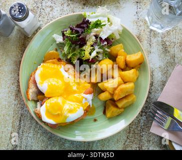 Portion of eggs benedict toast with salmon and potatoes closeup Stock Photo