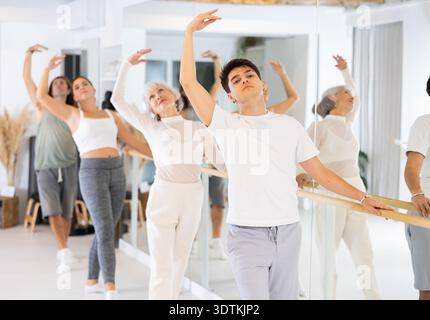 Diligent young man doing choreography at ballet barre Stock Photo