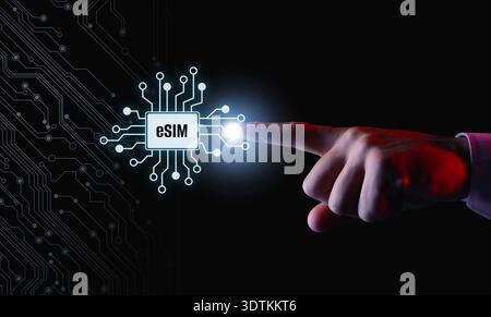 Businessman activating eSIM microchip on virtual screen, closeup. Black background with circuit board pattern Stock Photo