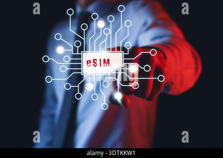 Businessman activating eSIM microchip on virtual screen, closeup. Dark background Stock Photo