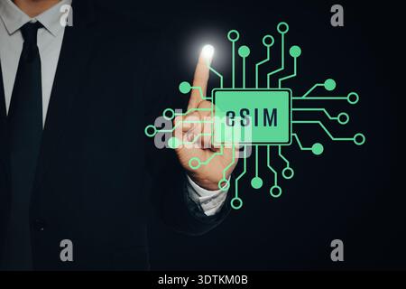 Businessman activating eSIM microchip on virtual screen, closeup. Black background Stock Photo