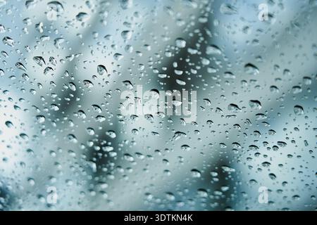 Raindrops on glass with blurred background. Stock Photo