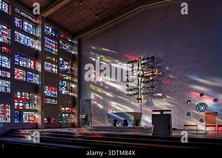 Cologne, Germany February 07 2023: Interior view of St. Pankratius in Cologne. Sunlight through stained glass concrete windows creates colorful light Stock Photo
