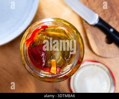 Homemade pickled cucumber salad wild peppers and carrots in jar Stock Photo