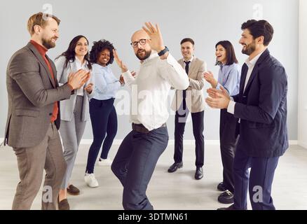 Business people in office suits dancing having fun and celebrate their success in business Stock Photo