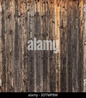Close-up of an old weathered wooden surface fence or a wall made of vertical planks Stock Photo