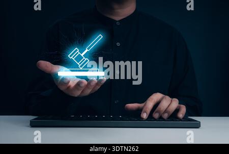 Person holding virtual digital gavel icon while using keyboard computer. AI laws, use of artificial intelligence technology in legal practice, and fut Stock Photo