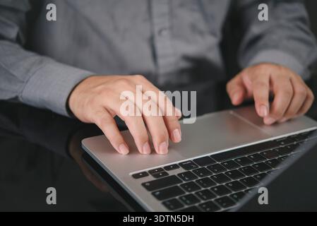 Close-up hand on laptop. Businessman working on computer, office desk. Navigating website, online browsing. Business technology concept, digital work, Stock Photo