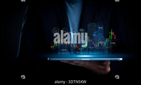 Businessman hand hold tablet show real estate investment hologram. City building graph chart. Property technology data analysis. Future stock market f Stock Photo