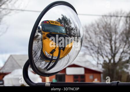 Mirroring of the yellow schoolbus on its own external mirror Stock Photo