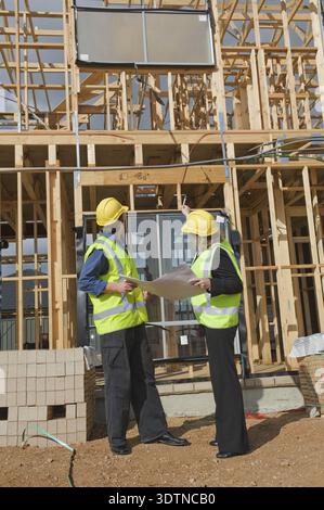 Civil engineer and worker discussing issues at the construction site Stock Photo