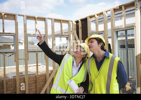 Civil engineer and worker discussing issues at the construction site Stock Photo