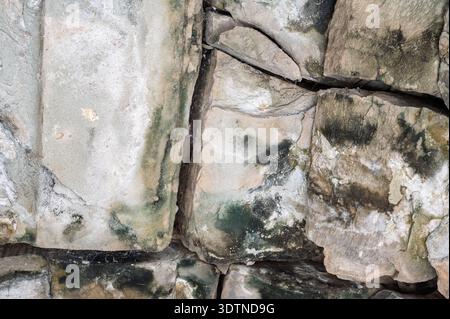 Grey stone wall texture close up cracks moss ancient masonry surface grunge background nature architecture weathered rough block detail abstract conce Stock Photo
