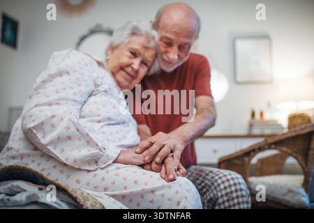 Elderly spouses sharing quiet moment before sleep. Stock Photo