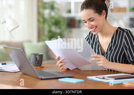 Happy self employed putting documents in transparent file holder working at home Stock Photo