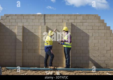 Civil engineer and worker discussing issues at the construction site Stock Photo