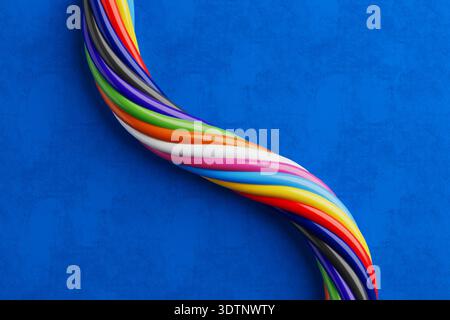 Twisted Electrical Wires Concept. Glossy Multicolor Cables Intertwined In Spiral Shape On Blue Background. 3d Rendering Stock Photo
