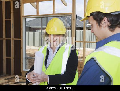 Civil engineer and worker discussing issues at the construction site Stock Photo
