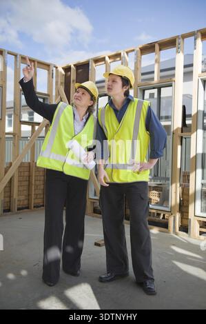 Civil engineer and worker discussing issues at the construction site Stock Photo