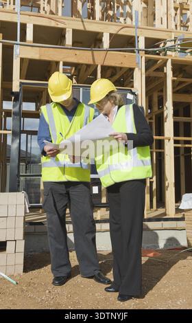 Civil engineer and worker discussing issues at the construction site Stock Photo