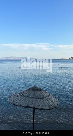 Blue sea and sky through a straw parasol Stock Photo