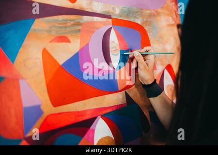 Close up of female artist hand painting eccentric modern painting Stock Photo
