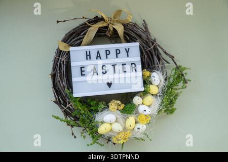 HAPPY EASTER text Handmade Easter wreath festive yellow egg decorations. Traditional holiday preparation craft creative decor. Sustainable responsible holiday gift workshop creation. Copy space Simple ideas green lifestyle Stock Photo