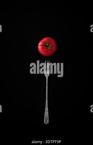 A tomato and silver fork. Stock Photo