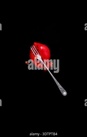 A squashed tomato and silver fork. Stock Photo