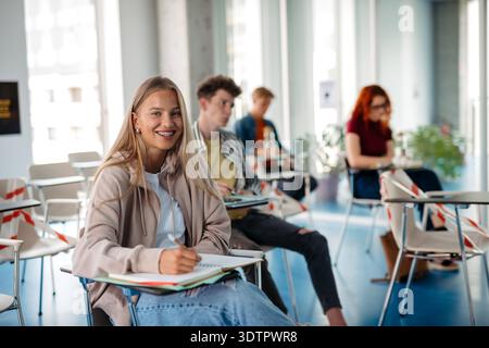 Group of college students attending lecture in university hall. Group of college students attending lecture in university hall. Diverse university stu Stock Photo