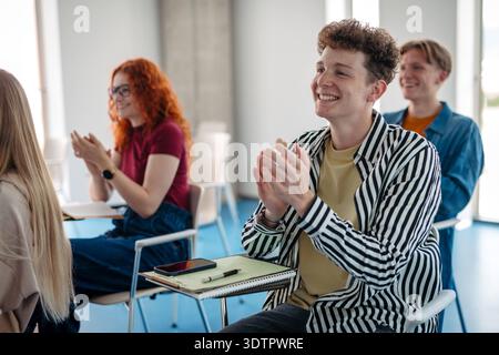 Group of college students attending lecture in university hall. Group of college students attending lecture in university hall. Diverse university stu Stock Photo