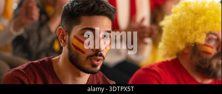 Nervous football fans supproting spanish national team in live soccer match at stadium. Nervous football fans supproting spanish national team in live Stock Photo