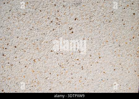 Full frame close-up of light beige stippled wall render texture with small speckled specks. Stock Photo