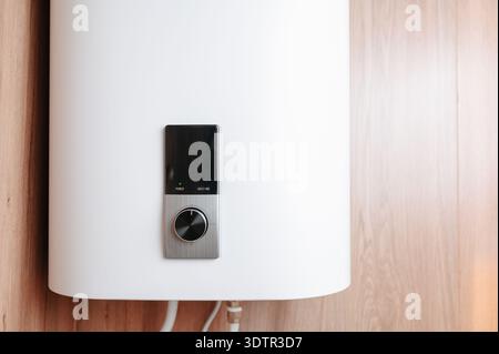 Contemporary Home Water Heater Installed On Wooden Panel With Accessible Control Knobs And Piping Stock Photo
