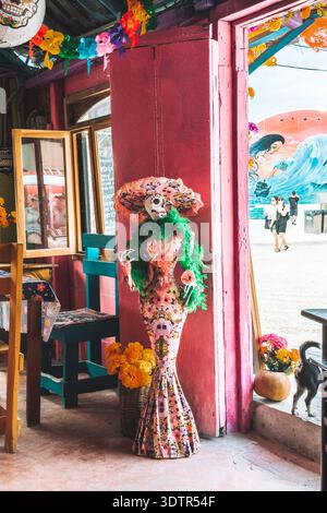 Elegant Catrina statue decorated with flowers inside colorful shop in Holbox, Mexico. Stock Photo