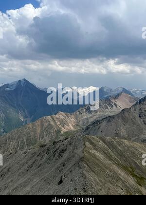 Breathtaking Mountain Vista: A Majestic Landscape of Peaks and Clouds Under a Dramatic Sky Stock Photo
