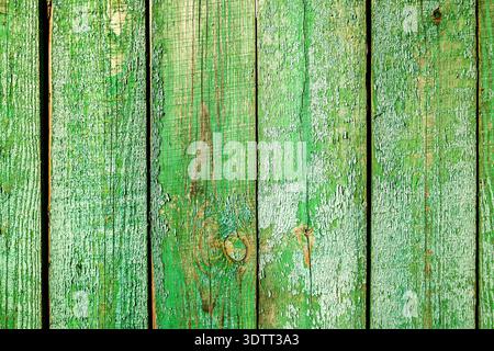 Old rough wooden boards with cracks as creative background in green color. Wooden planks texture with the shabby paint Stock Photo