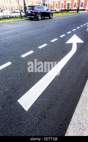 Traffic sign white arrows on asphalt road close up. Arrow sign on asphalt Stock Photo