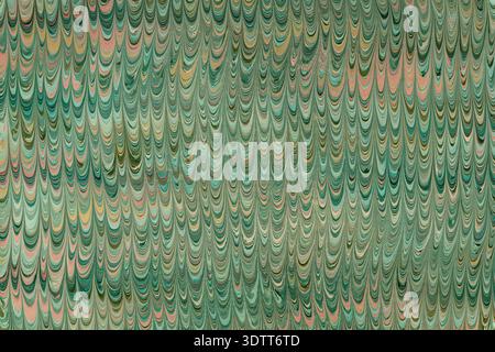 Marbled paper presents a traditional swirl pattern in green and pink tones Stock Photo