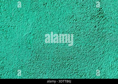 Full frame close-up of a vibrant turquoise teal textured wall surface with rough plaster structure. Stock Photo