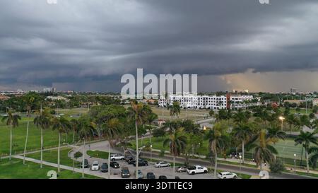 Aerial view of brooding storm clouds gather over the lush green landscape and buildings of West Palm Beach, Florida, United States. Stock Photo