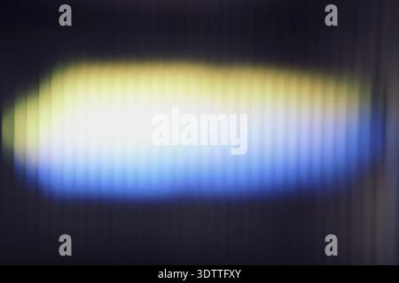 Blurred ribbed glass with vertical lines and glow on dark background Stock Photo