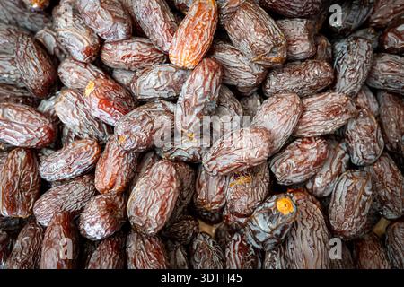 Close-up of dates for sale on a food market stall, showing the rich colour, texture and abundance of this traditional dried fruit in a natural retail Stock Photo