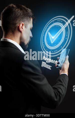 Man makes banking invoice payment using smartphone in modern setting Stock Photo