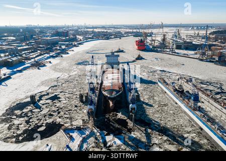 Aerial Riga Shipyard in winter with dry dock on frozen Daugava River Stock Photo